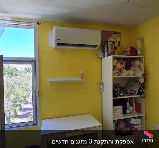 מזגן מותקן על קיר צהוב בחדר שינה.